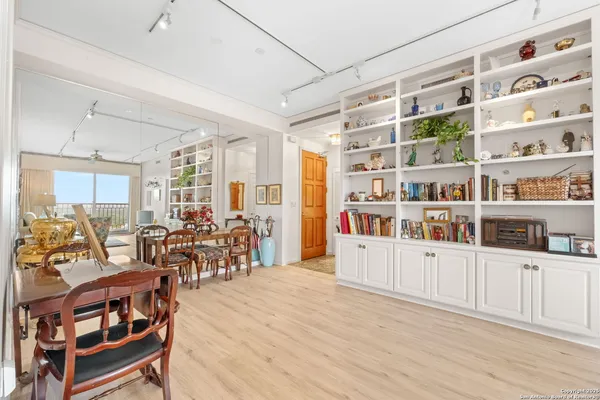a living room with furniture cabinets and wooden floor