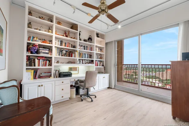 a view of a workspace with furniture and a window