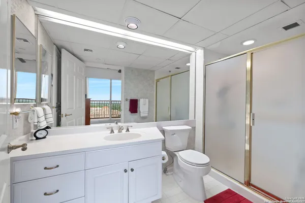 a bathroom with a toilet sink double vanity and mirror