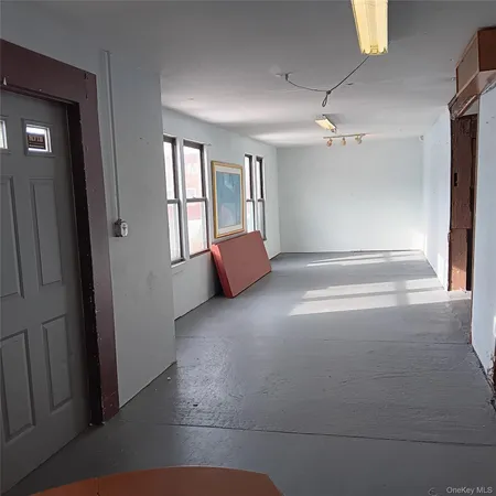 an empty room with windows and cabinet