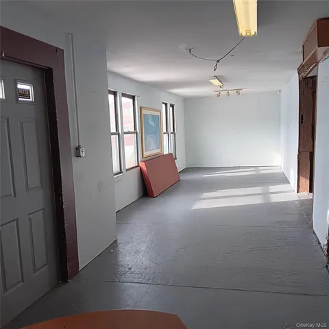 an empty room with windows and cabinet