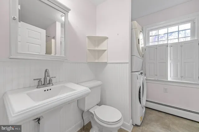 a bathroom with a sink a toilet and a window