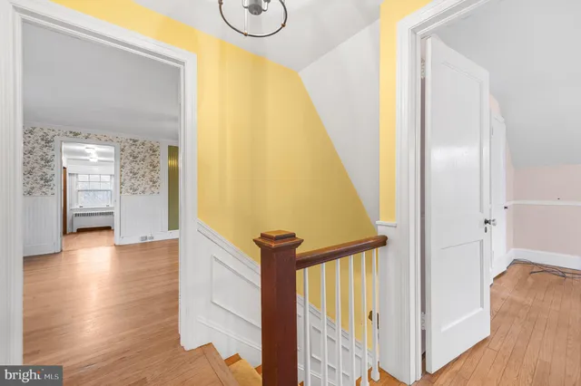 a view of a hallway with wooden floor and stairs