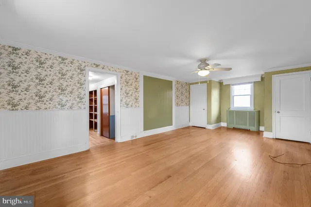 a view of a big room with wooden floor and windows