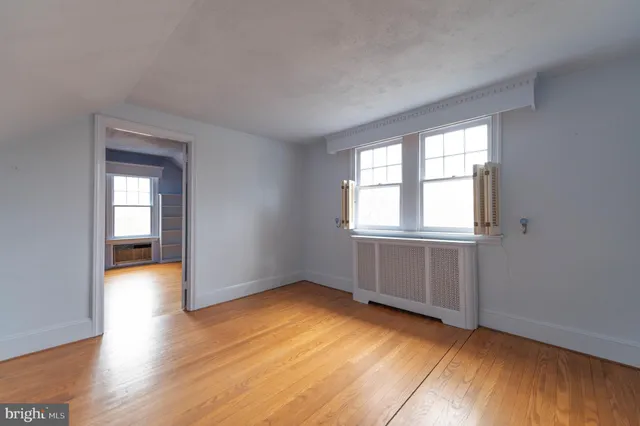 a view of an empty room with wooden floor