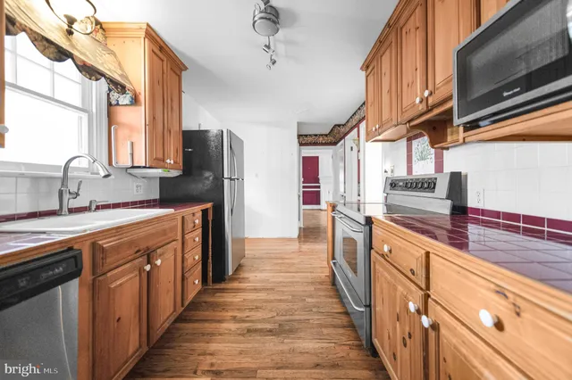 a large kitchen with stainless steel appliances sink a microwave and cabinets