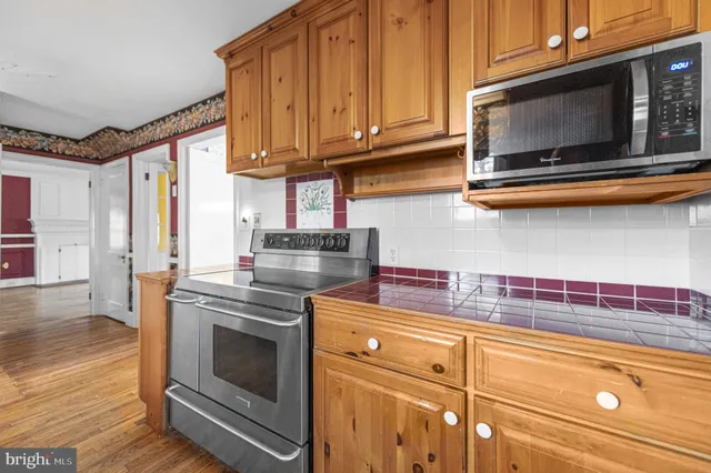 a kitchen with stainless steel appliances granite countertop a stove microwave and cabinets