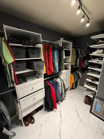 a view of walk in closet with clothes and shoes