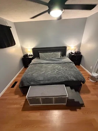 a bed sitting in a bedroom next to a lamp