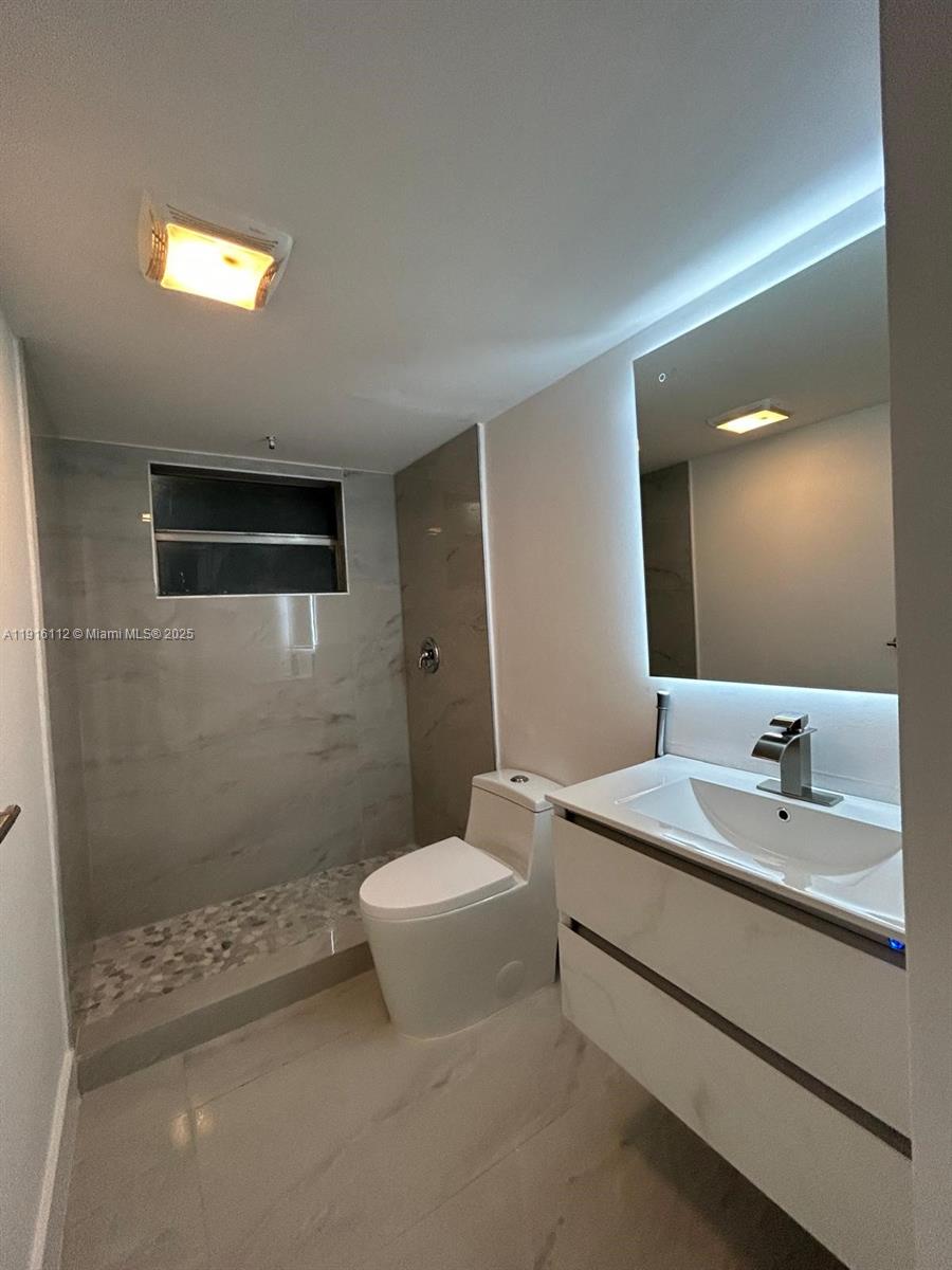 1750 Northeast 191st Street, Unit 4264 Miami, FL 33179 - Photo 11 of 21 a bathroom with a sink a toilet and shower