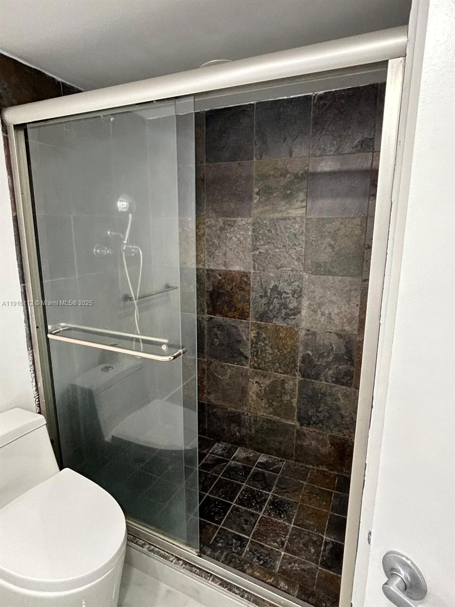 1750 Northeast 191st Street, Unit 4264 Miami, FL 33179 - Photo 17 of 21 a bathroom with a shower and toilet