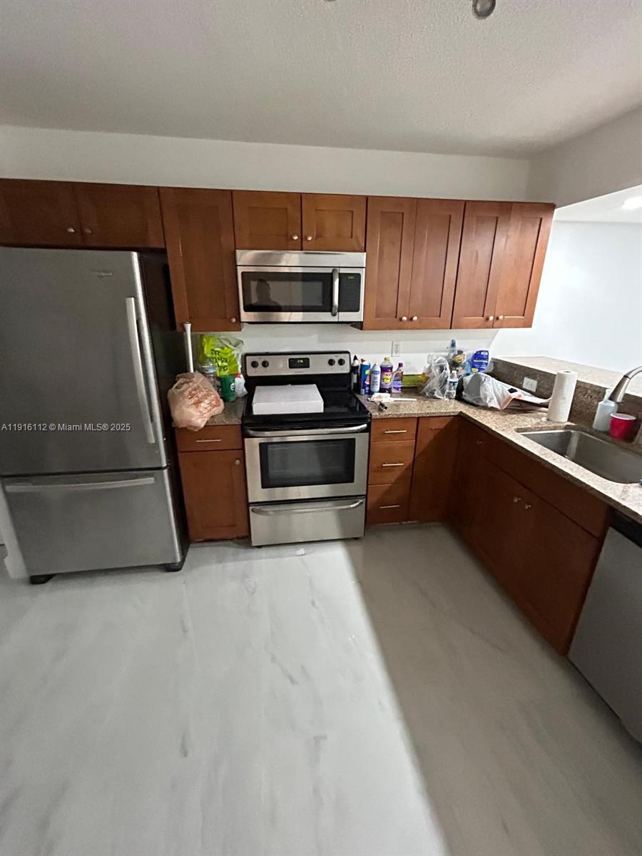 1750 Northeast 191st Street, Unit 4264 Miami, FL 33179 - Photo 2 of 21 a kitchen with stainless steel appliances and a stove top oven
