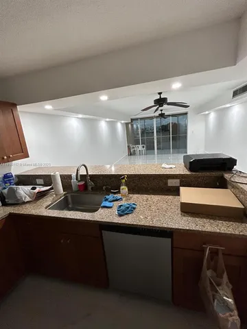 a kitchen with granite countertop a sink and a stove top oven