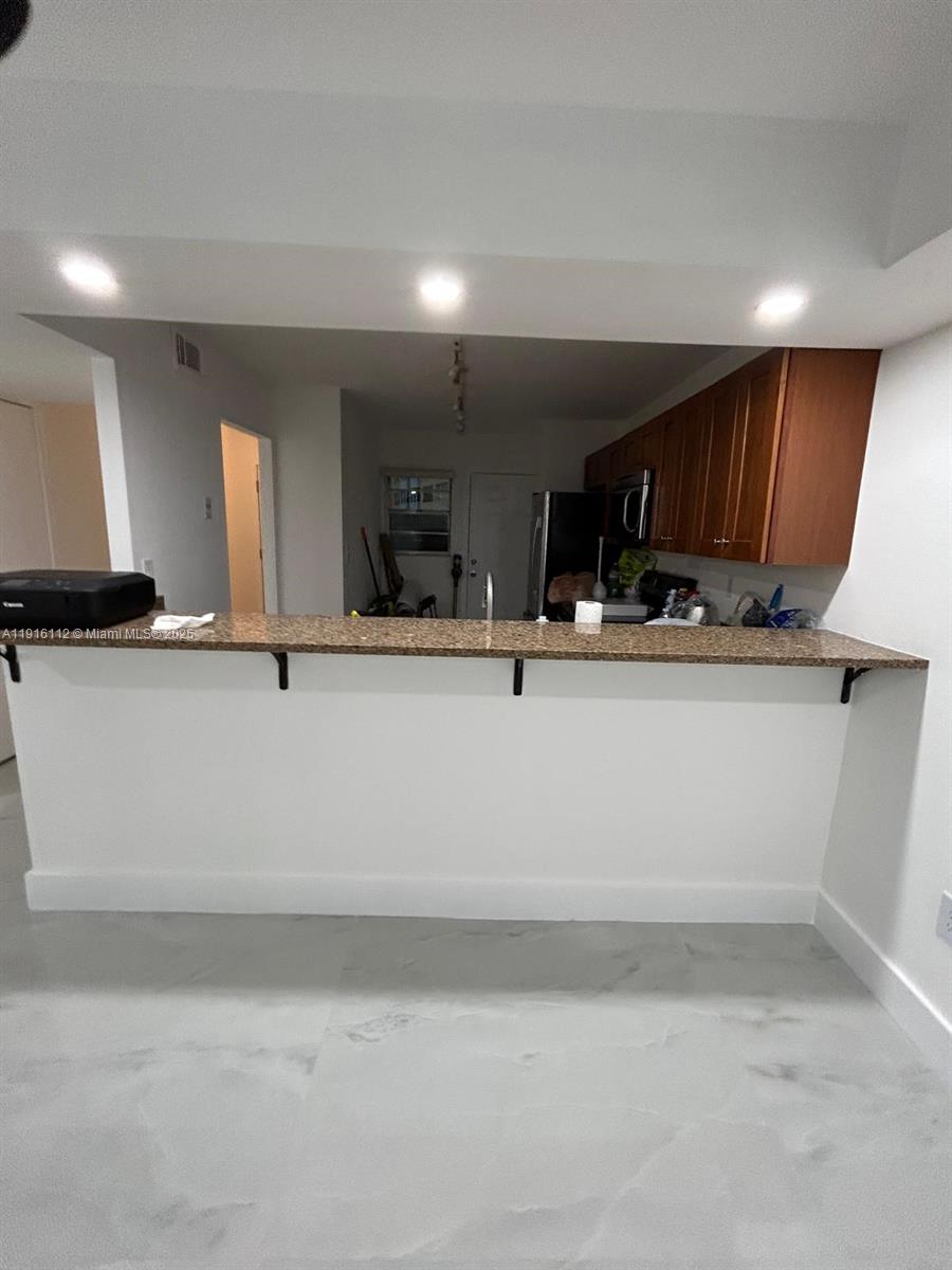 1750 Northeast 191st Street, Unit 4264 Miami, FL 33179 - Photo 5 of 21 a view of a kitchen with kitchen island a sink stainless steel appliances and cabinets