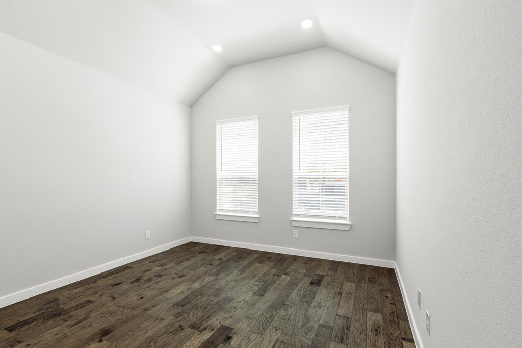 3311 Willena Road Melissa, TX 75454 - Photo 32 of 40 Vaulted ceilings enhance this room featuring two windows with blinds, recessed lighting, and wood-finish flooring