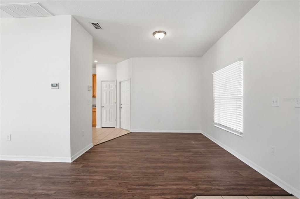 7702 Dragon Fly Loop Gibsonton, FL 33534 - Photo 15 of 42 an empty room with wooden floor and windows
