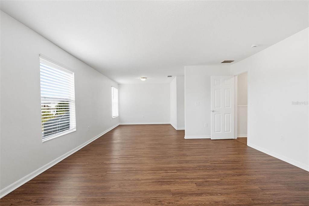 7702 Dragon Fly Loop Gibsonton, FL 33534 - Photo 23 of 42 a view of an empty room with wooden floor and a window