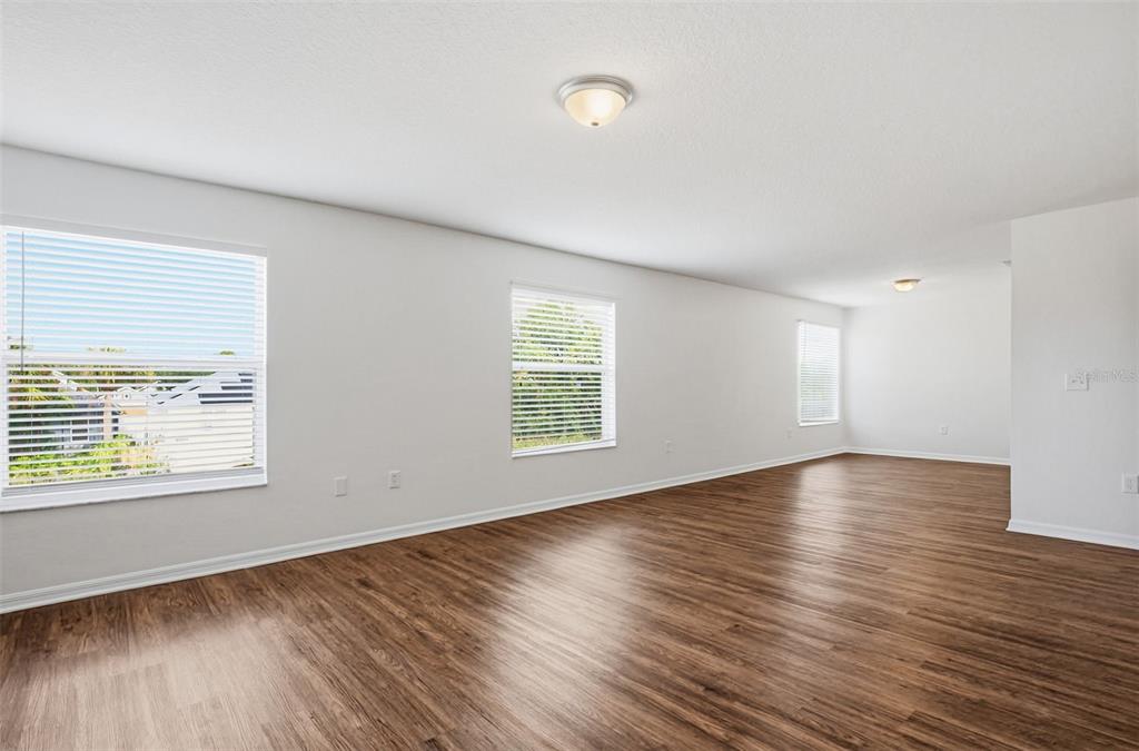 7702 Dragon Fly Loop Gibsonton, FL 33534 - Photo 25 of 42 an empty room with wooden floor and windows