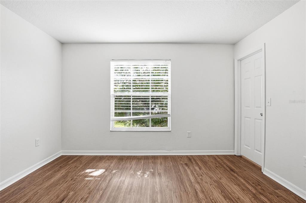 7702 Dragon Fly Loop Gibsonton, FL 33534 - Photo 28 of 42 an empty room with wooden floor and windows