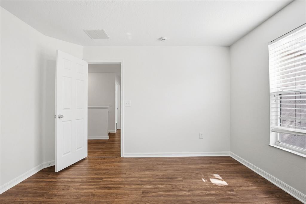 7702 Dragon Fly Loop Gibsonton, FL 33534 - Photo 29 of 42 an empty room with wooden floor and windows