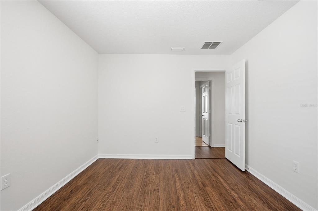 7702 Dragon Fly Loop Gibsonton, FL 33534 - Photo 34 of 42 a view of an empty room with wooden floor and a window