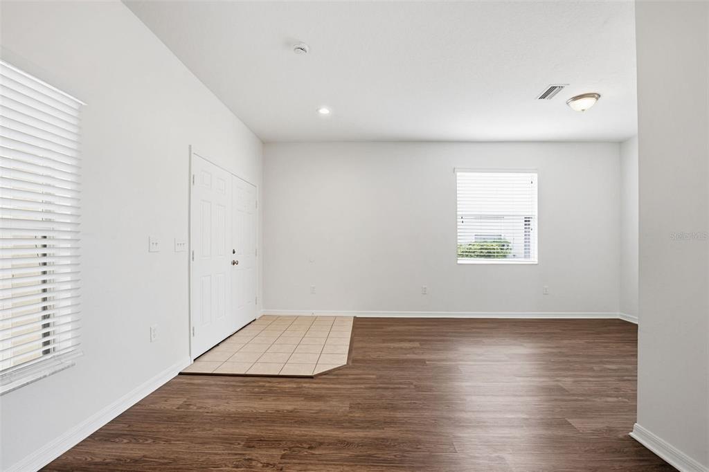 7702 Dragon Fly Loop Gibsonton, FL 33534 - Photo 5 of 42 an empty room with wooden floor and windows