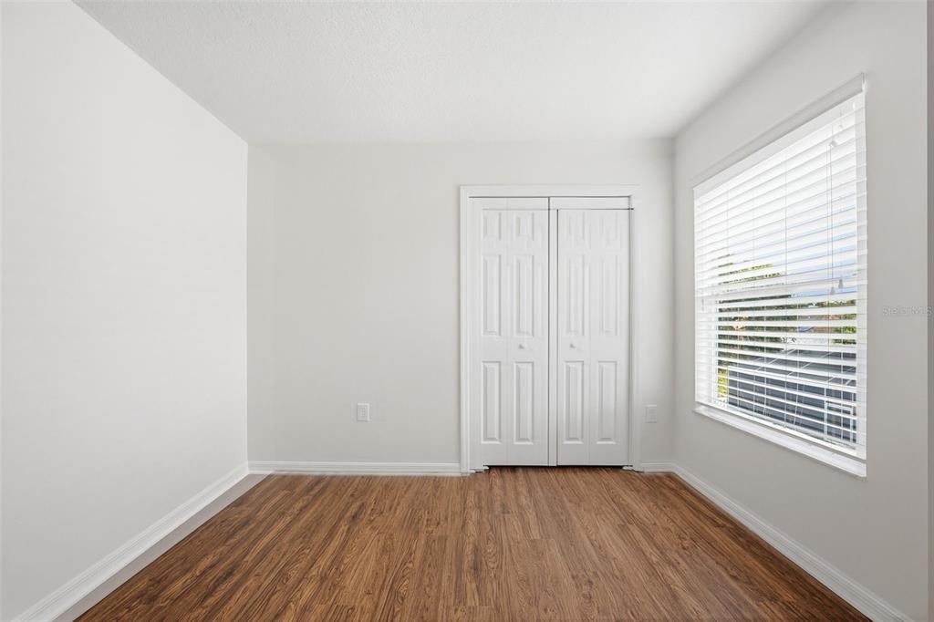 7702 Dragon Fly Loop Gibsonton, FL 33534 - Photo 9 of 42 an empty room with wooden floor and windows