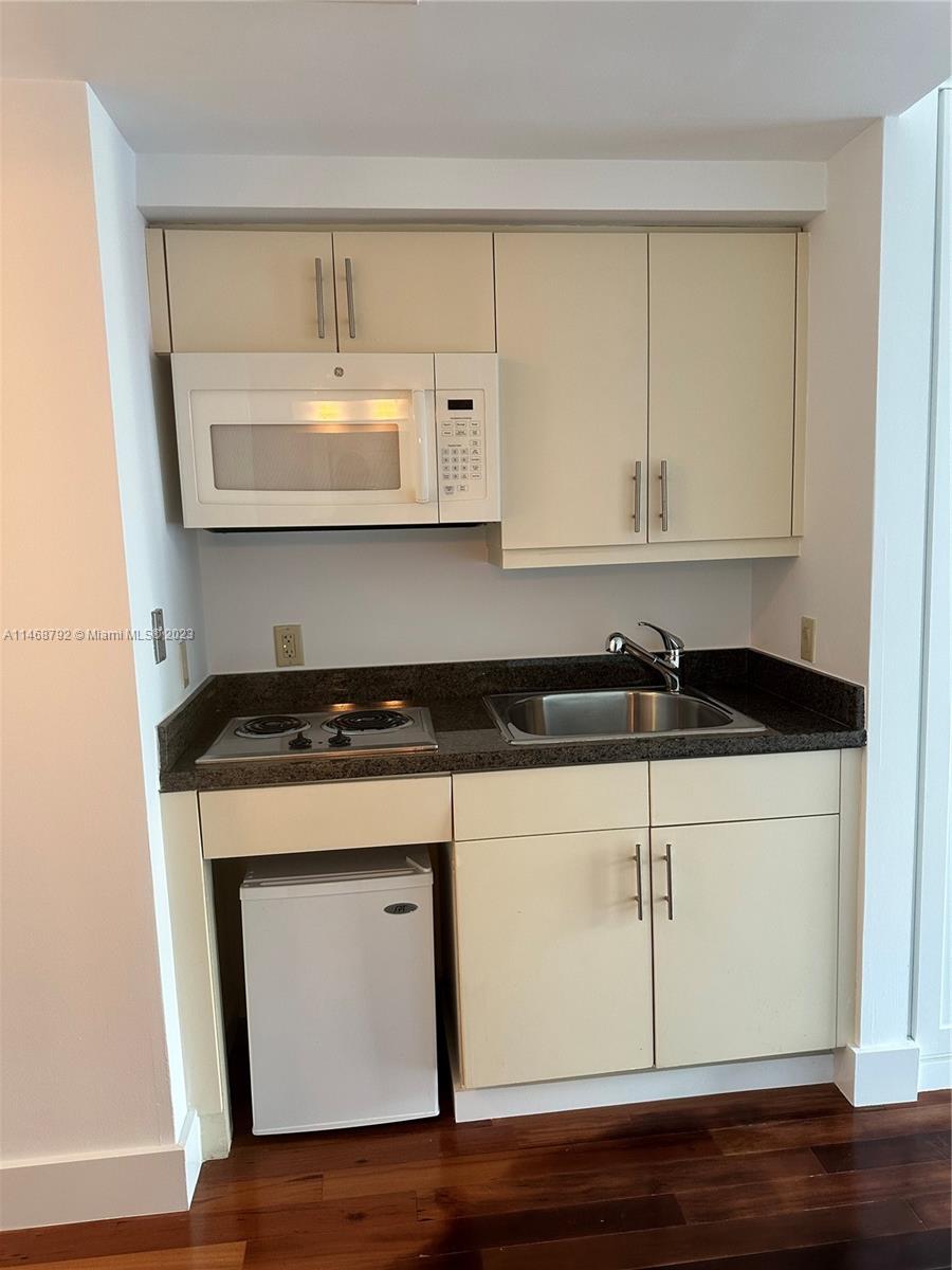 2889 McFarlane Road, Unit 903 Miami, FL 33133 - Photo 5 of 10 a close view of a stove a sink and a microwave