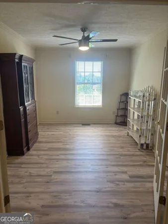 a view of empty room with window and wooden floor
