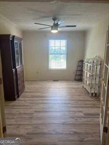 a view of empty room with window and wooden floor