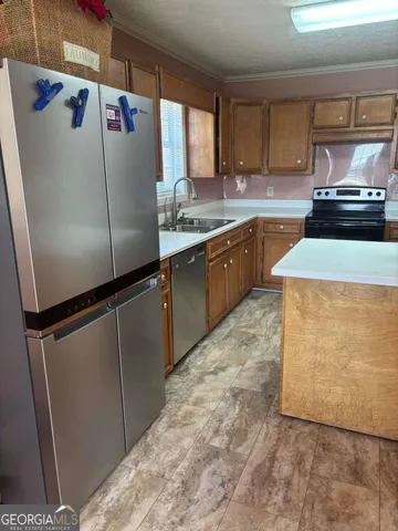 a kitchen with granite countertop a refrigerator and a sink
