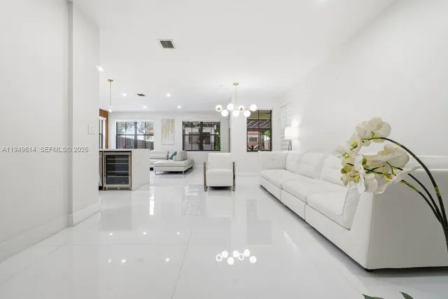 a living room with furniture and a dining table with wooden floor
