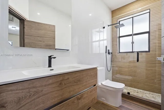 a bathroom with a toilet a sink and shower