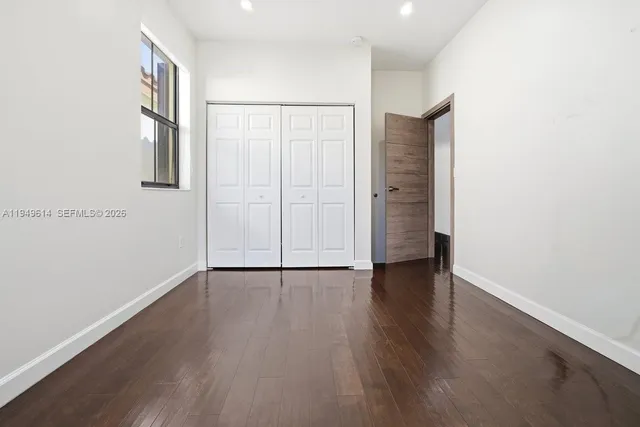 an empty room with wooden floor and closet