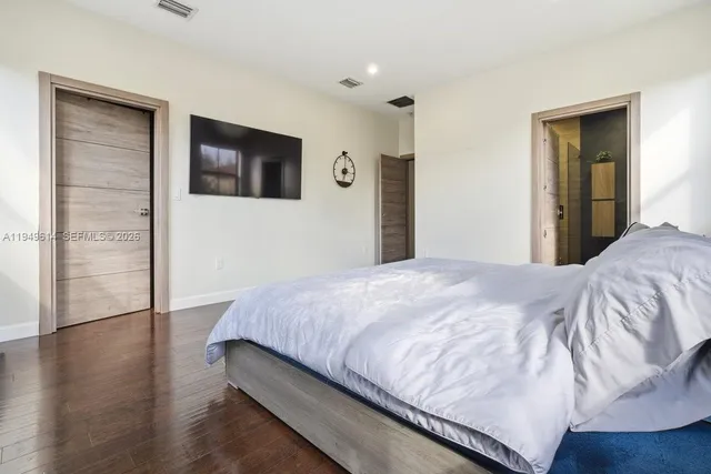 a bedroom with a bed and wooden floor