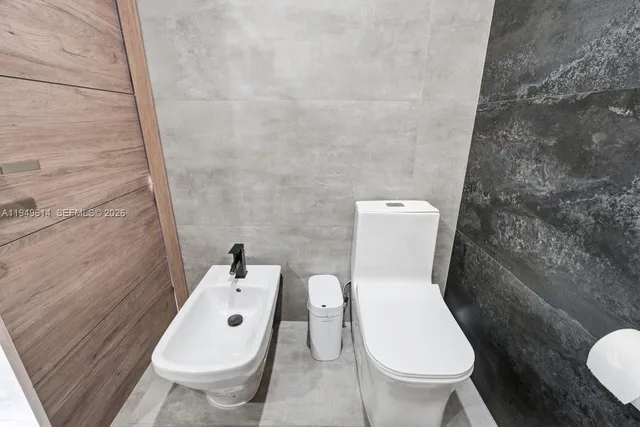 a white toilet sitting next to a small sink