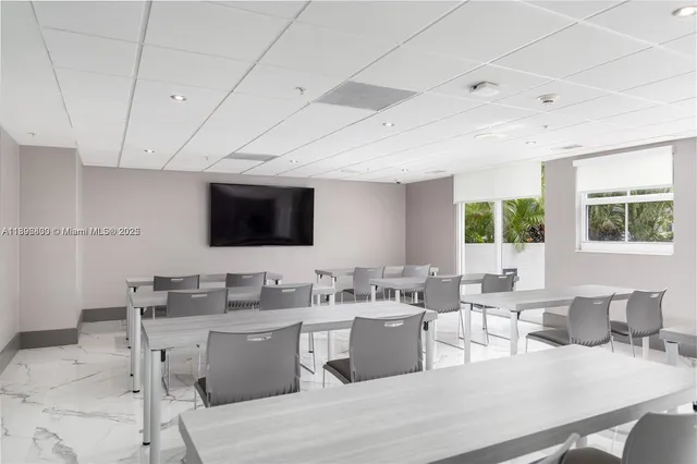 a living room with a large window wooden floor dining table and chairs