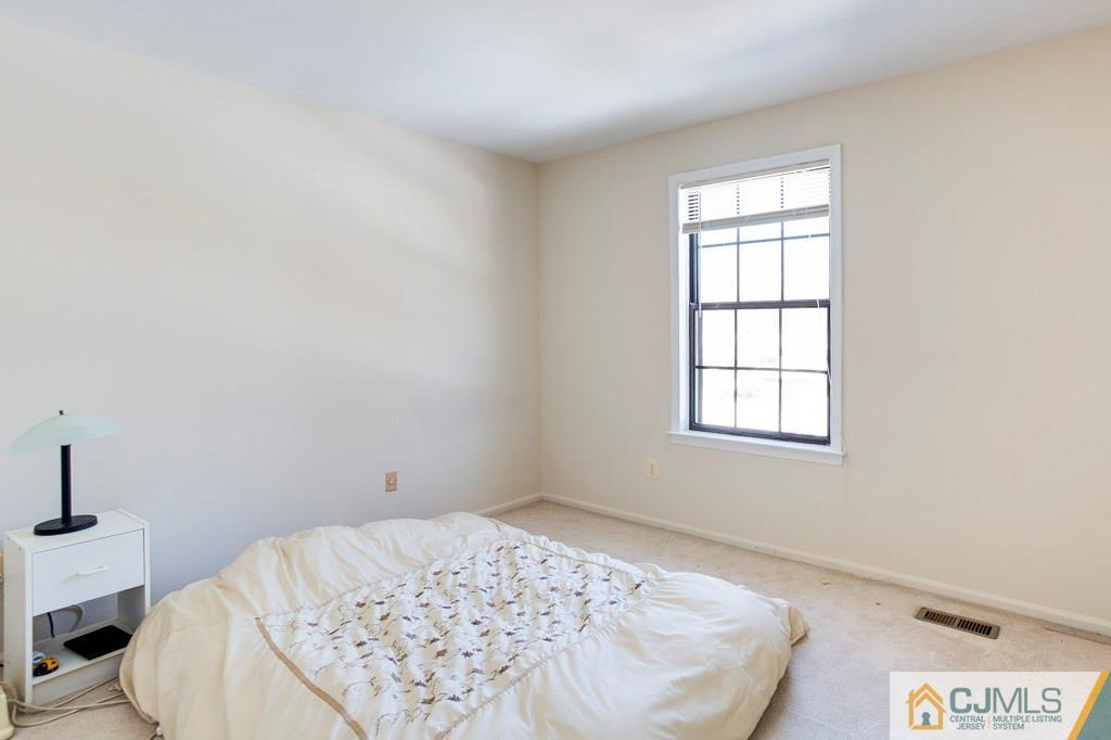 4401 Stonehedge Road, Unit 44 Edison, NJ 08820 - Photo 15 of 24 a view of a bedroom with a bed and a window