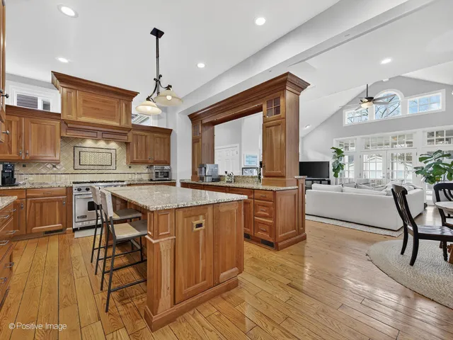 a open kitchen with stainless steel appliances granite countertop a stove and a wooden floors