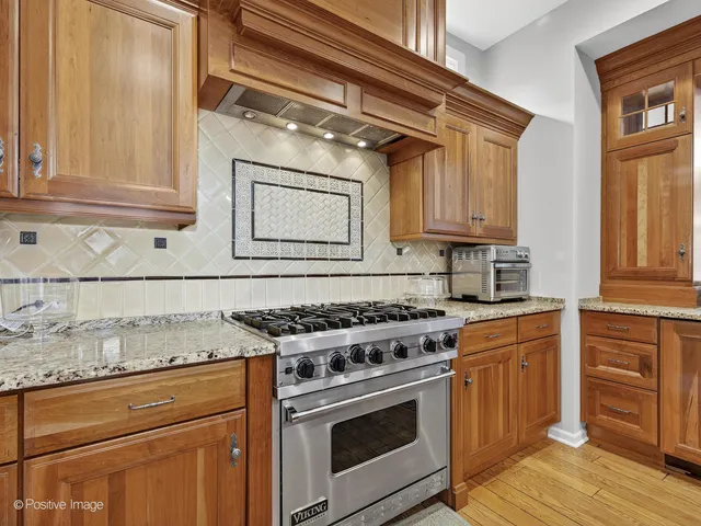 a kitchen with granite countertop a stove sink and cabinets