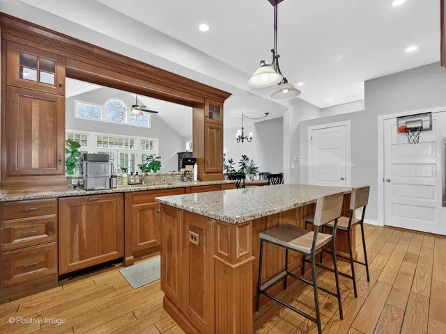 a kitchen with stainless steel appliances granite countertop wooden floor window and cabinets