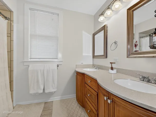 a bathroom with a granite countertop sink two mirror and a window