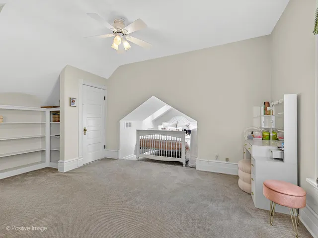 a spacious bedroom with a bed and a ceiling fan