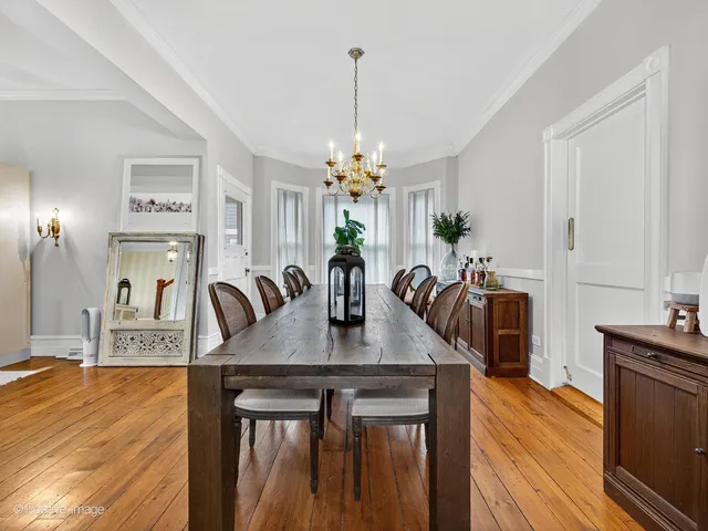 a dining room with furniture a chandelier and wooden floor