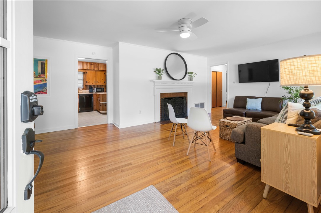 207 Brook Street Clemson, SC 29631 - Photo 5 of 39 Hardwood floors and a pristine white fireplace create an inviting, open-concept living area.