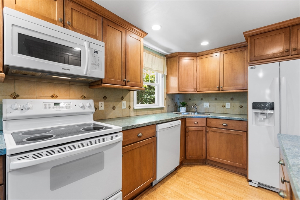 40 Bonad Road Stoneham, MA 02180 - Photo 7 of 38 a kitchen with stainless steel appliances granite countertop a stove microwave and cabinets