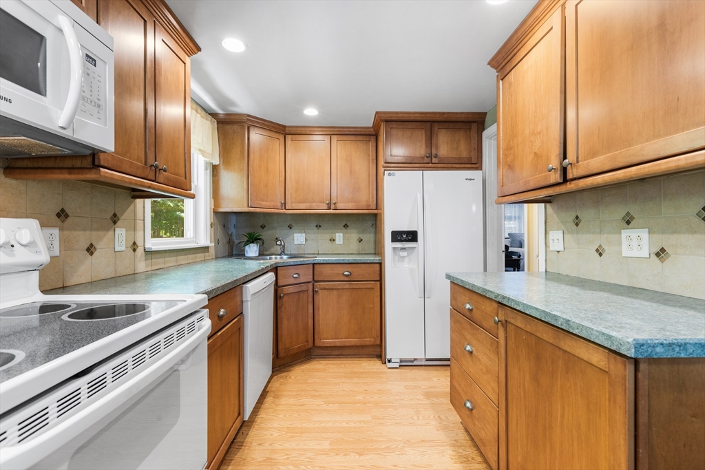 40 Bonad Road Stoneham, MA 02180 - Photo 8 of 38 a kitchen with stainless steel appliances granite countertop a sink a stove and a refrigerator