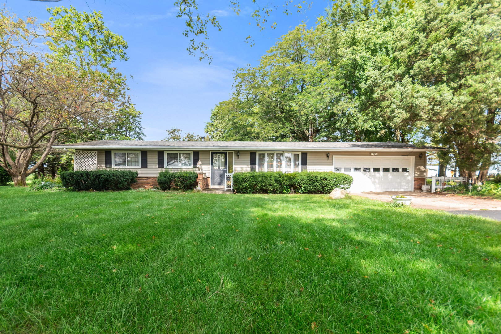 a view of house with backyard and a garden