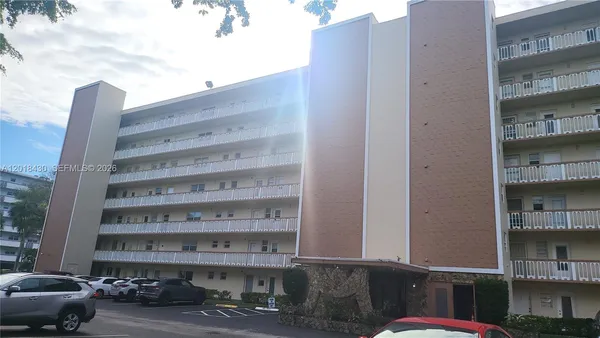 a view of building with cars parked in front of it