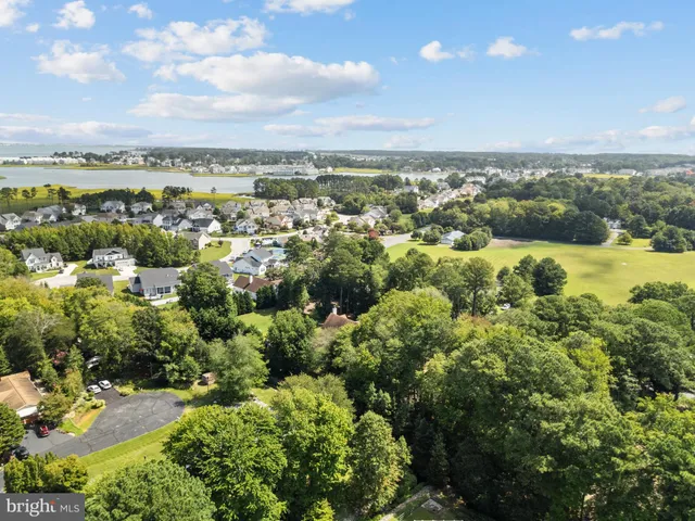 an aerial view of residential house with outdoor space and trees all around